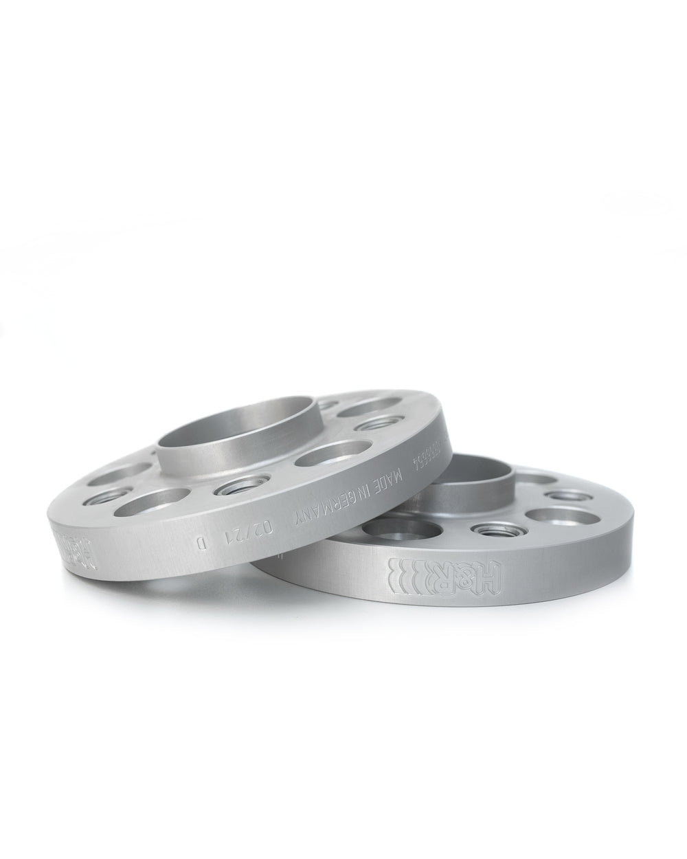 Zwei silberne, übereinander liegende Spurverbreiterungen der Marke H&R Spezialfedern, mit einem eingravierten H&R Logo, passend für Porsche 911
